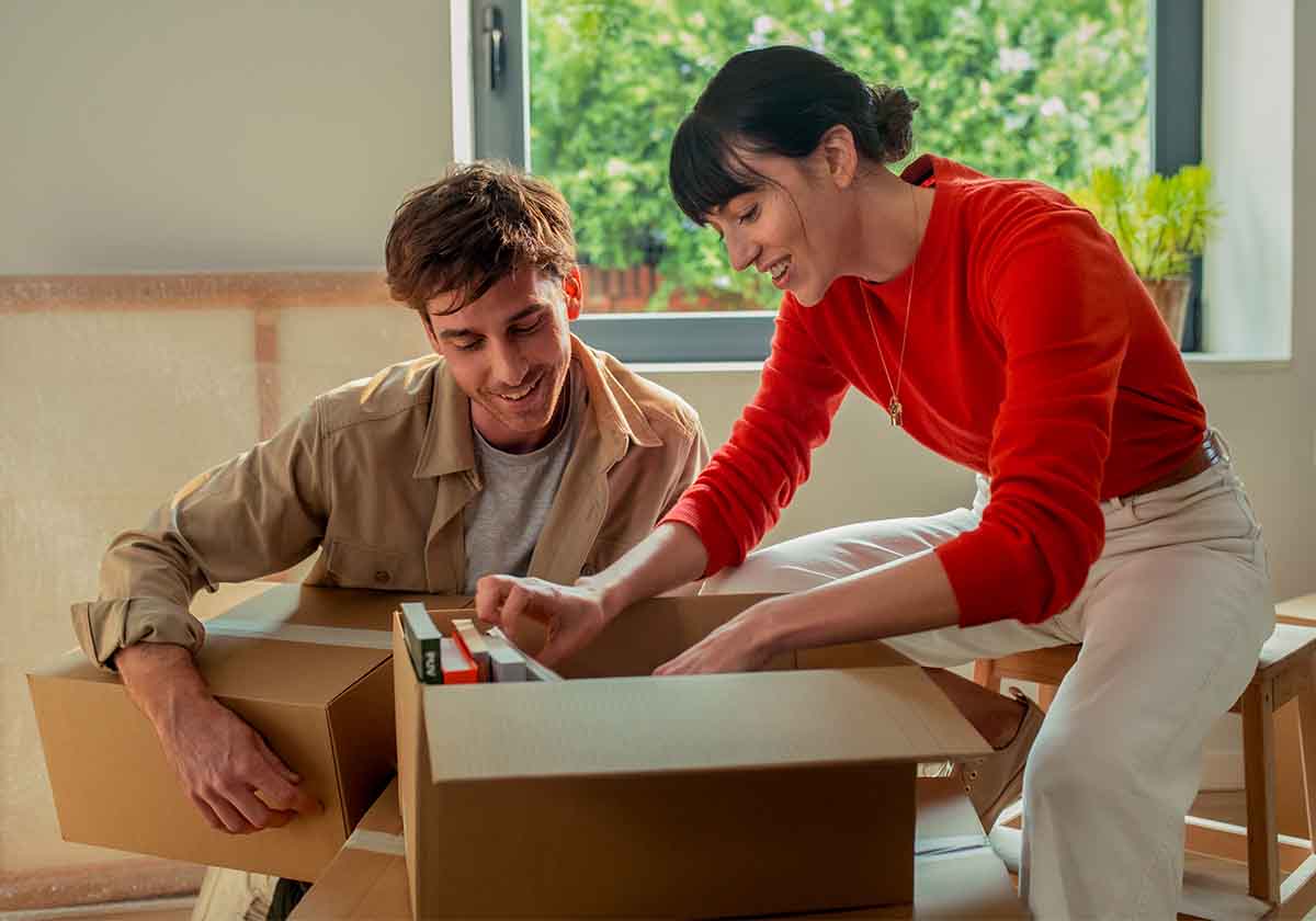 Pareja abriendo cajas de mudanza